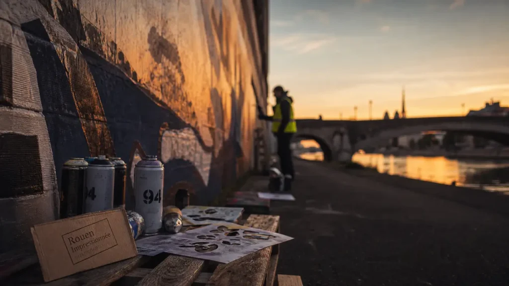 Street art rouen : fresque monumentale en cours sur mur au bord de la Seine
